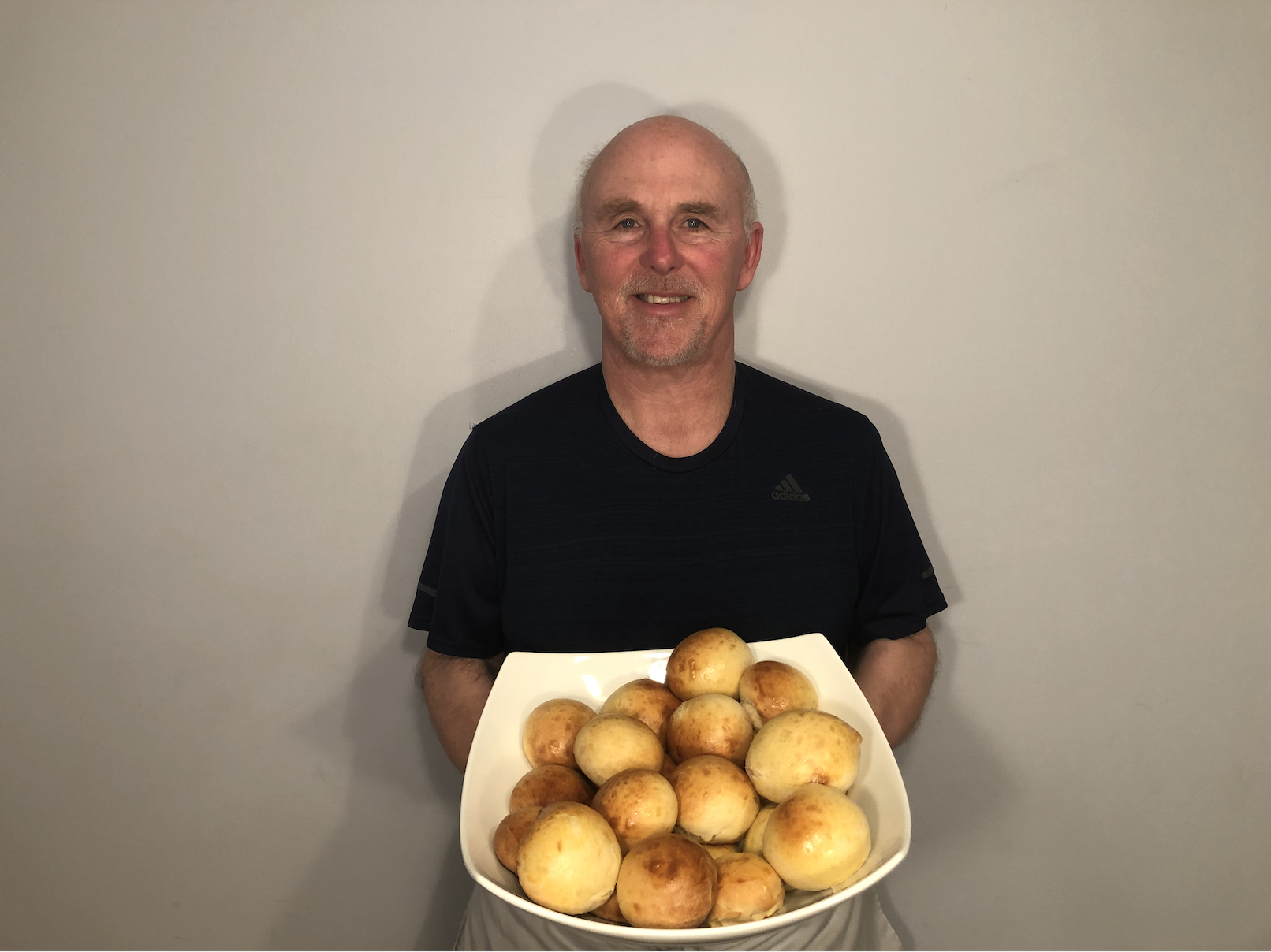 A photo of Chef Rob holding a plate of dinner rolls.