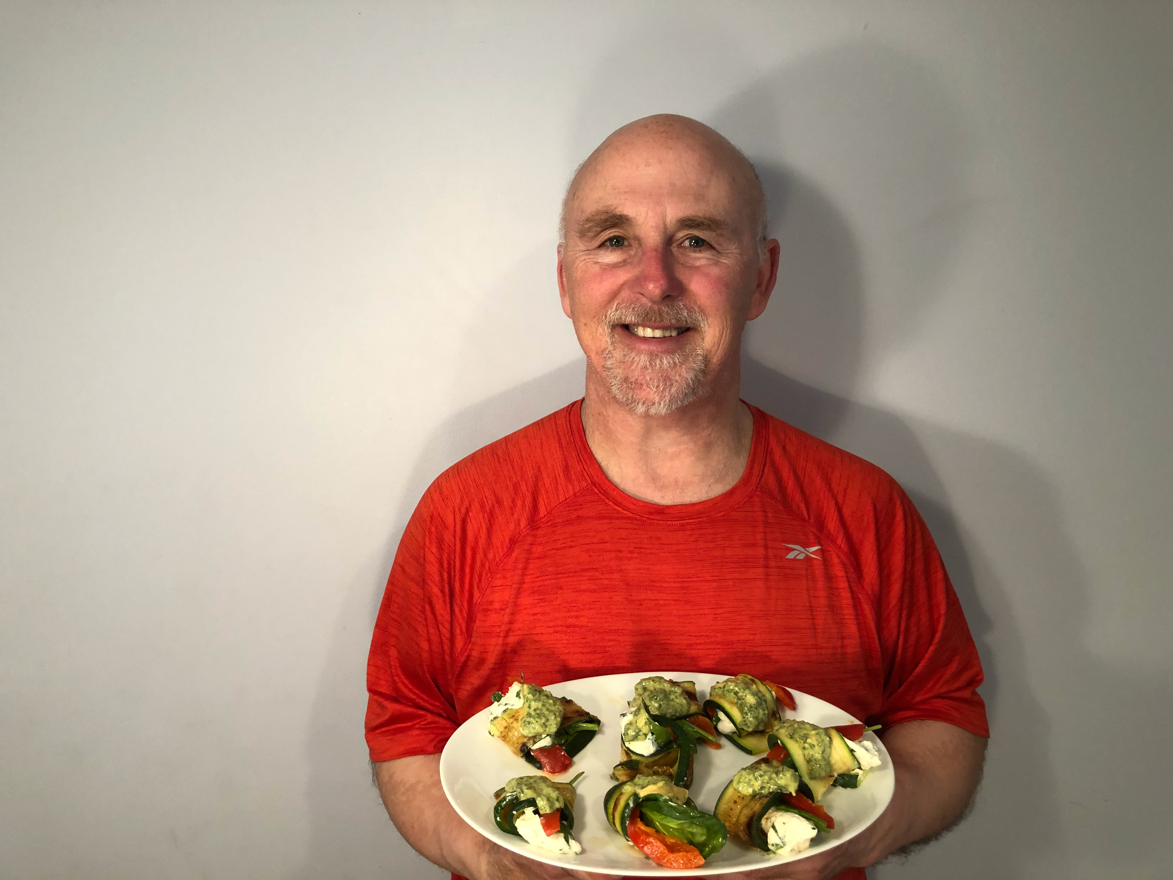 Photo of Chef Rob holding a plate of Grilled Zucchini Rolls.