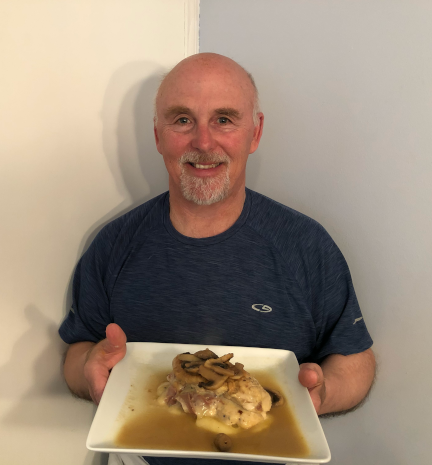 A photo of Chef Rob holding a plate of Chicken Marsala.