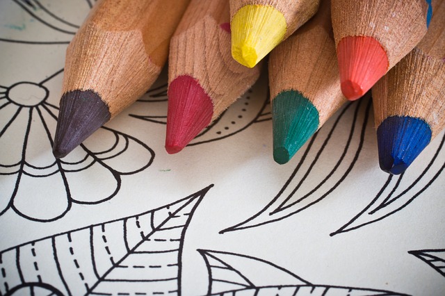 Photo of colored pencils atop a coloring sheet.