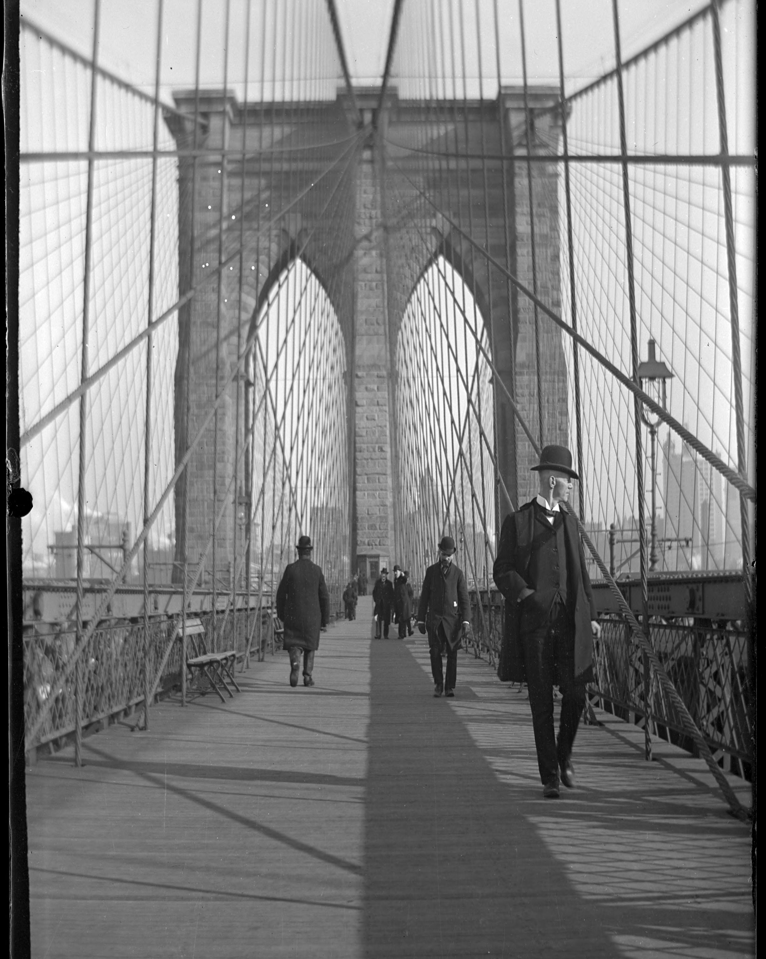 George Ehler Stonebridge, Man crossing the Brooklyn Bridge in winter, New York City, c. 1897-1905. Glass negative. New-York Historical Society.