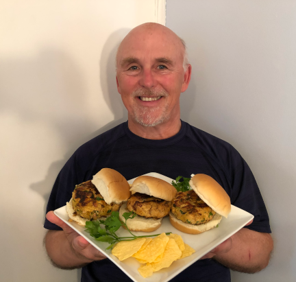 Photo of Chef Rob holding a plate of Salmon-Fuji Apple Burgers
