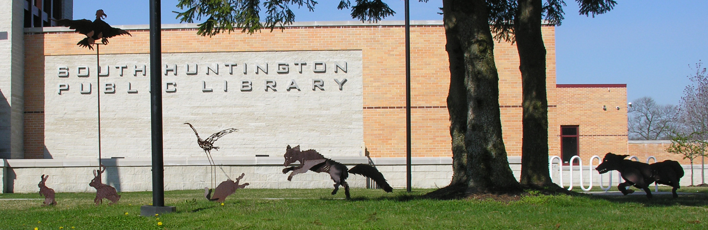 Steel fox chasing prey in front of South Huntington Public Library