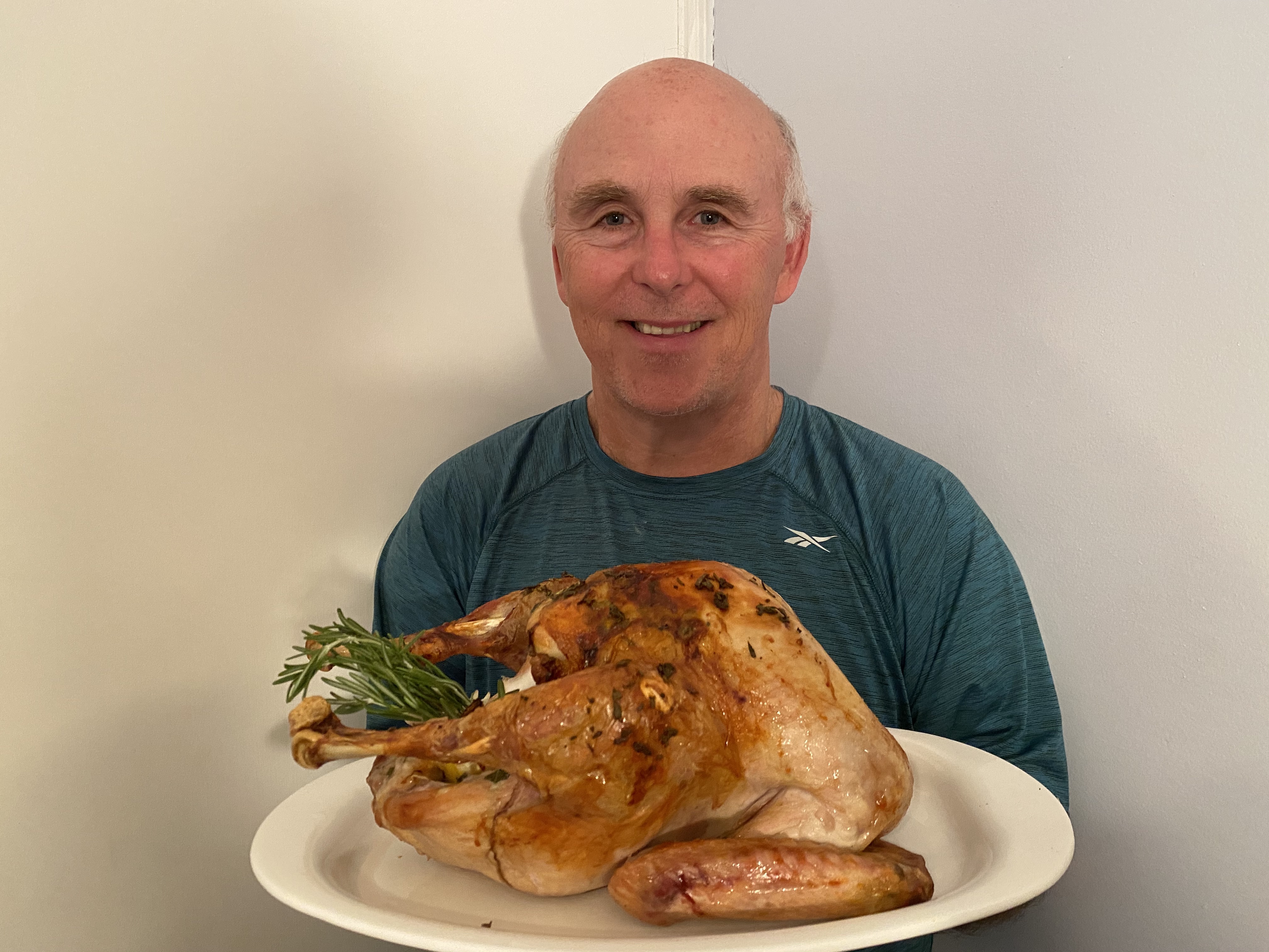 Photo of Chef Rob holding a platter with a roast turkey.