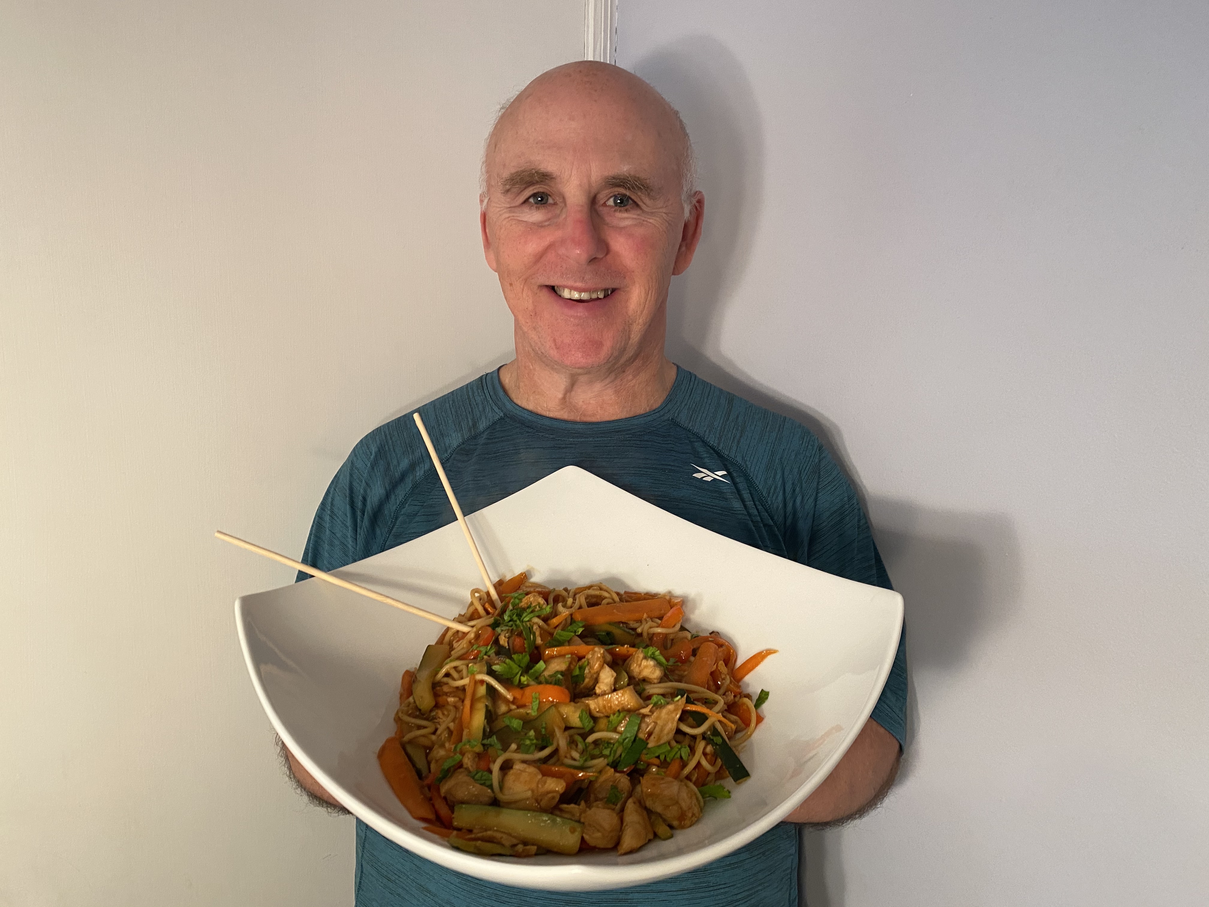 Photo of Chef Rob with a bowl of Dragon Noodles.