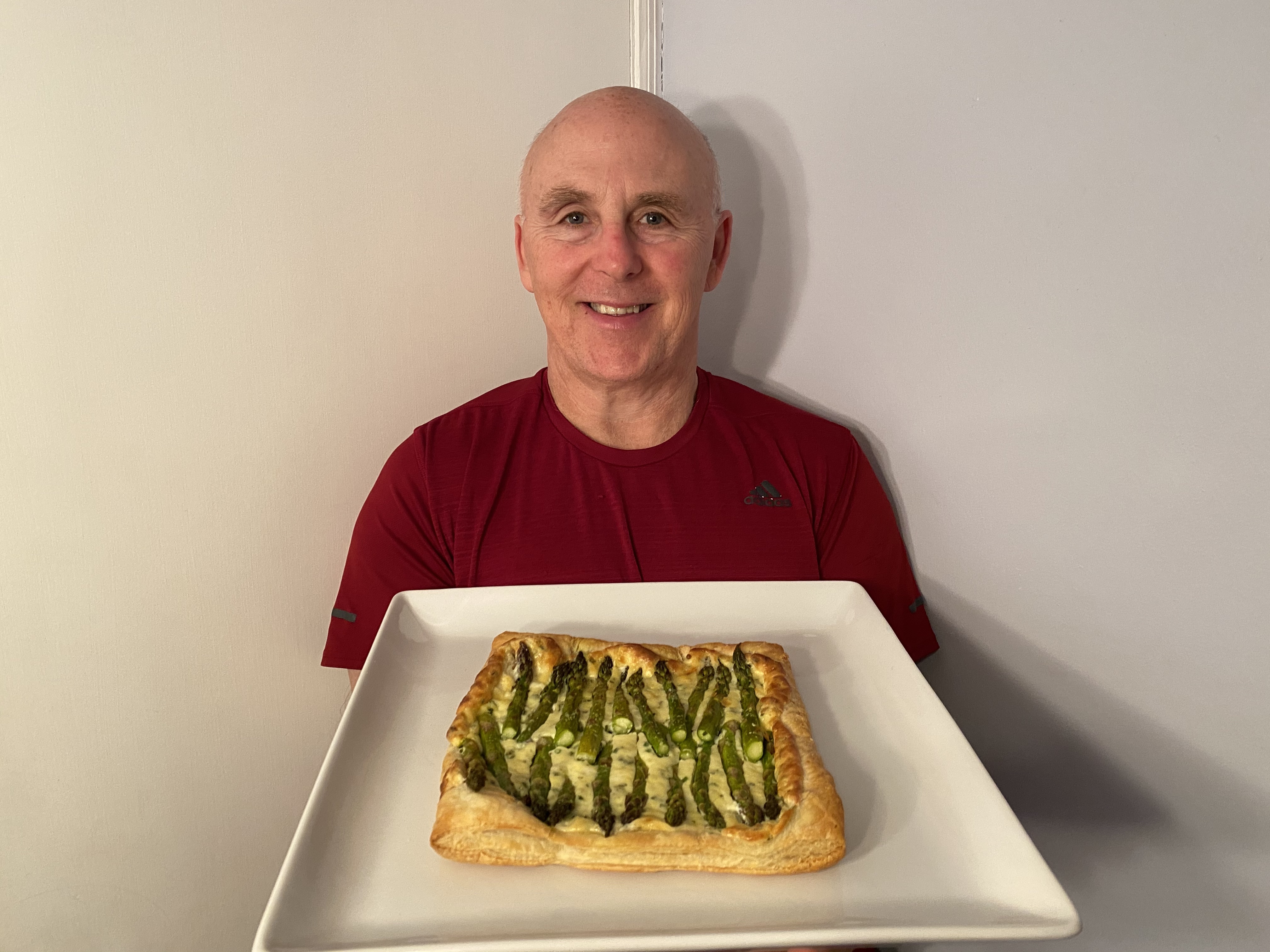 Photo of Chef Rob holding a plate of Spring Asparagus Tart with Mascarpone and Lemon.