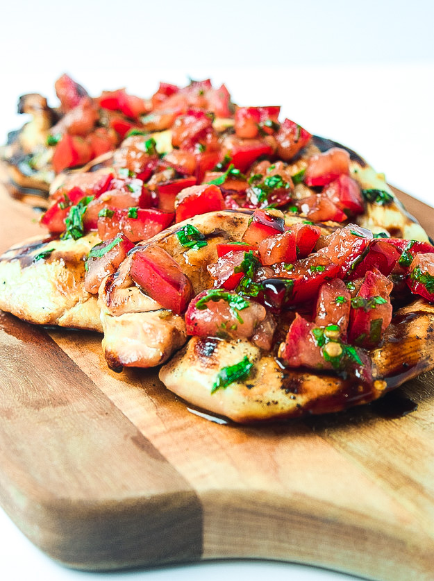 A photo of a wooden cutting board containing Balsamic Grilled Chicken Breasts.