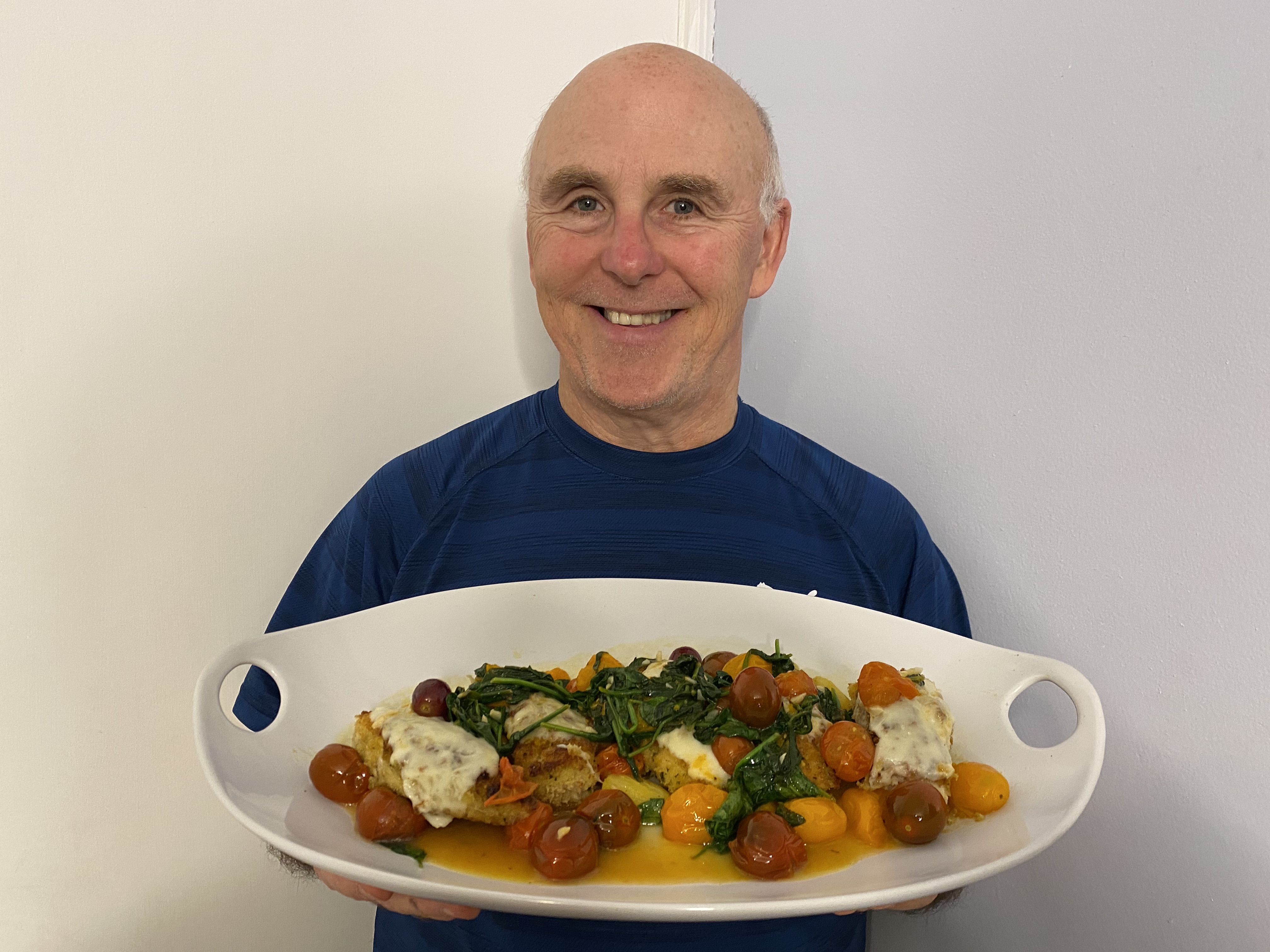 A photo of Chef Rob holding a plate of Panko Crusted Chicken with Fresh Mozzarella and Spinach.th 