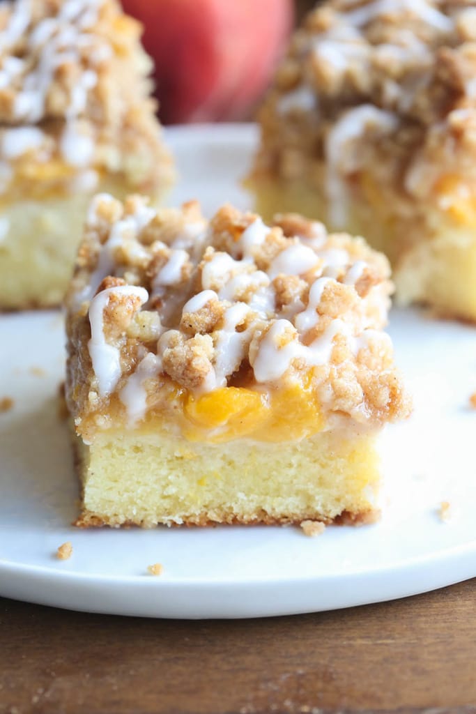 A photo of a piece of Peaches n Cream Crumb Cake on a plate.