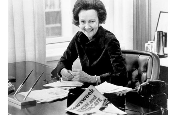 A black and white photo of Katharine Graham at her desk.