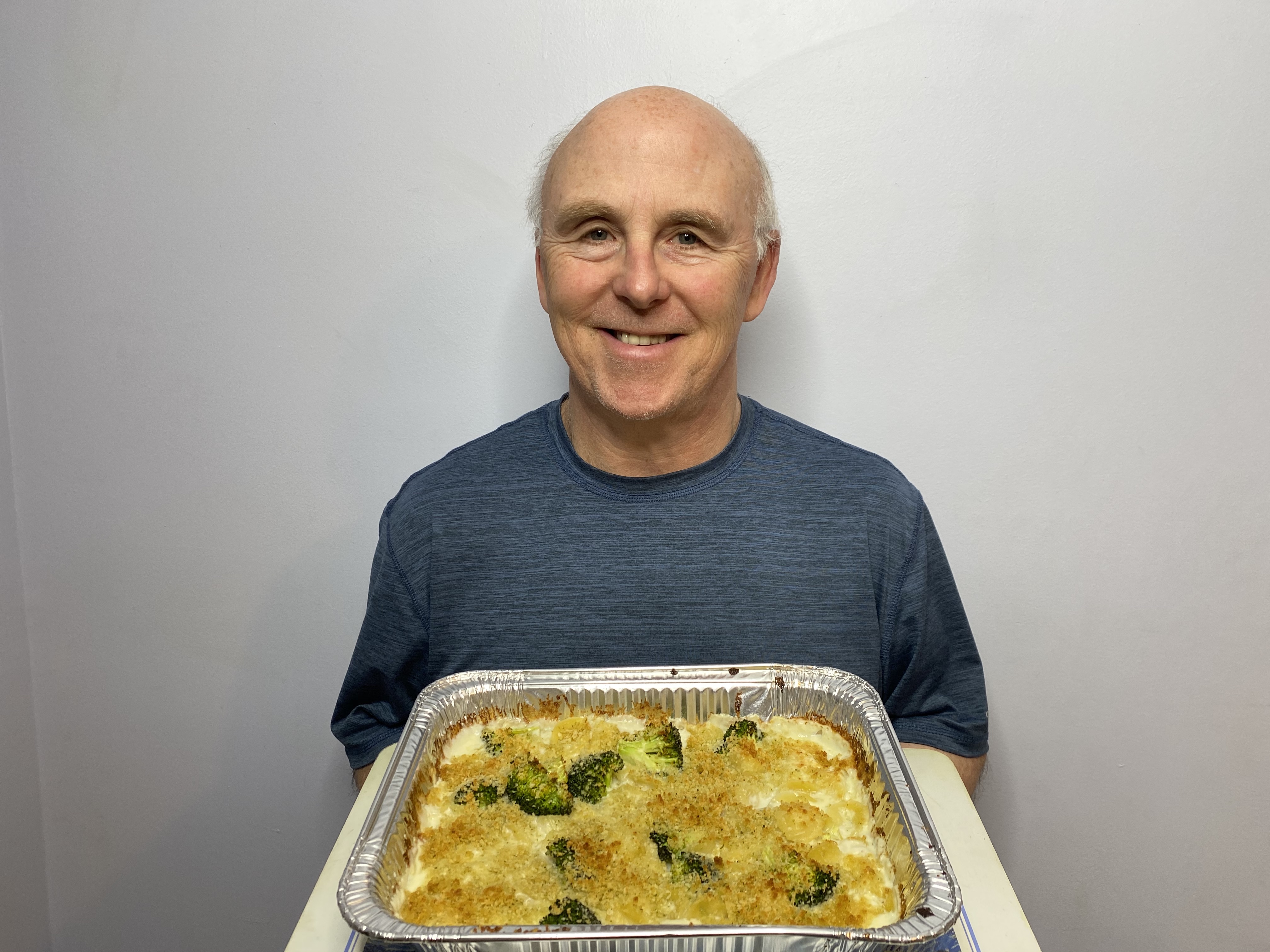 A photo of Chef Rob holding a dish of Provolone and Broccoli Baked Oriecchette Pasta.