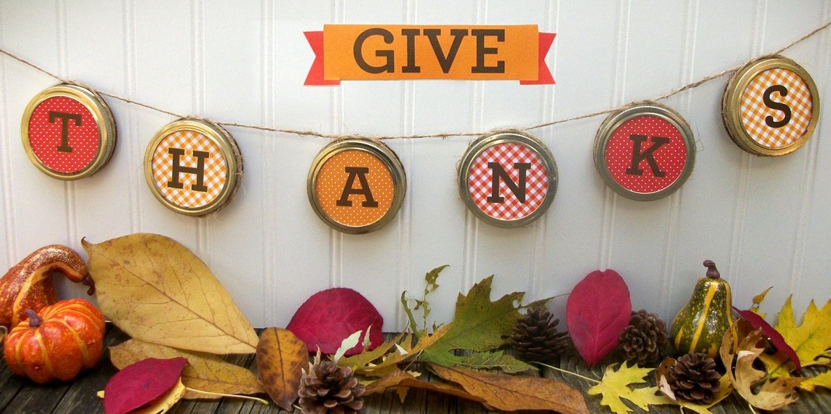 Photo of a Thanksgiving garland made from mason jar tops and twine.