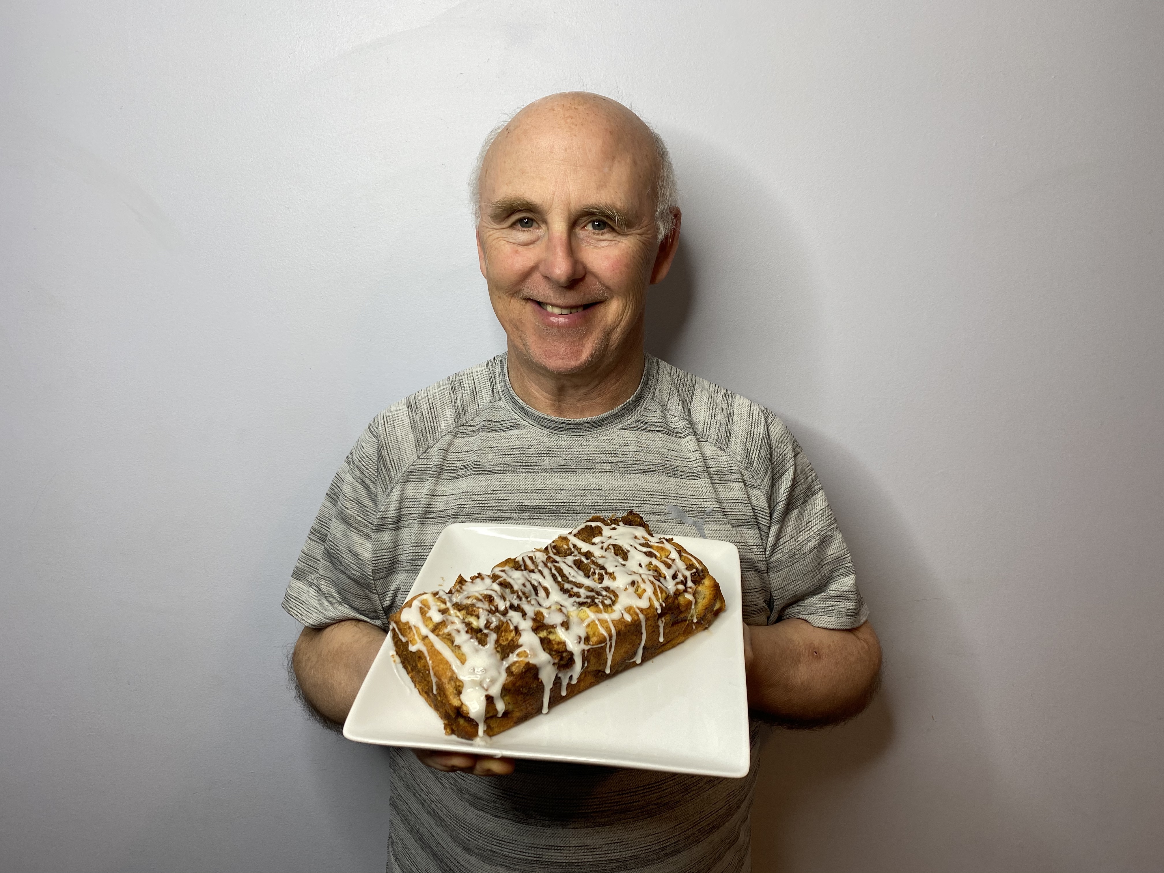 A photo of Chef Rob holding a plate with a loaf of Granny Smith Apple Fritter Bread.