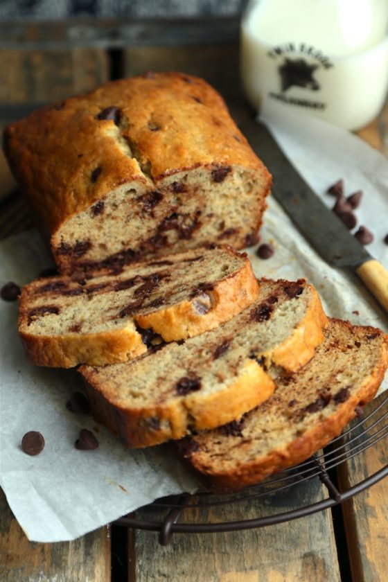 A photo of a partially sliced loaf of cinnamon swirl chocolate chip bread.