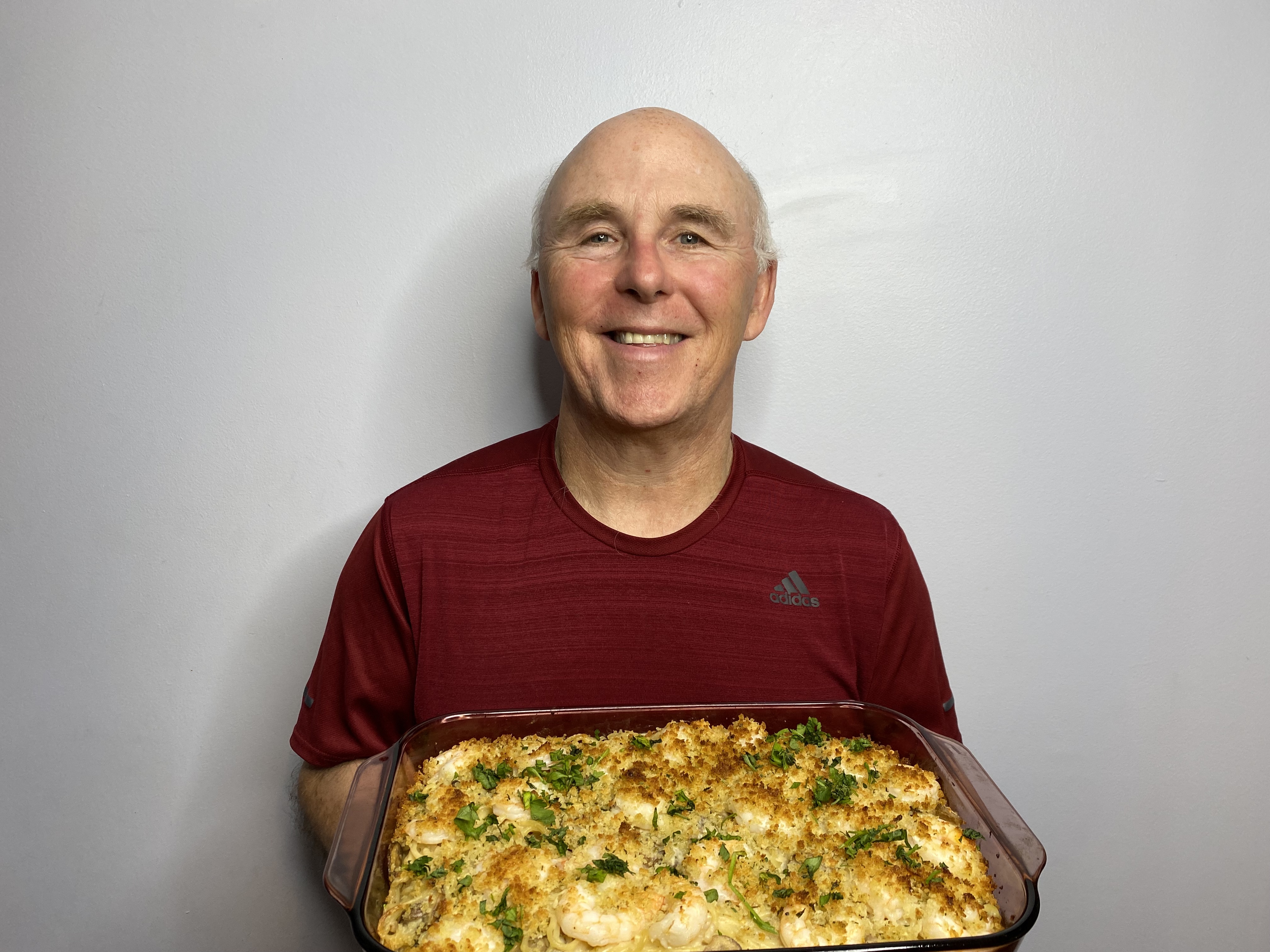 A photo of Chef Rob holding a dish of Baked Shrimp Scampi Tetrazzini Casserole.