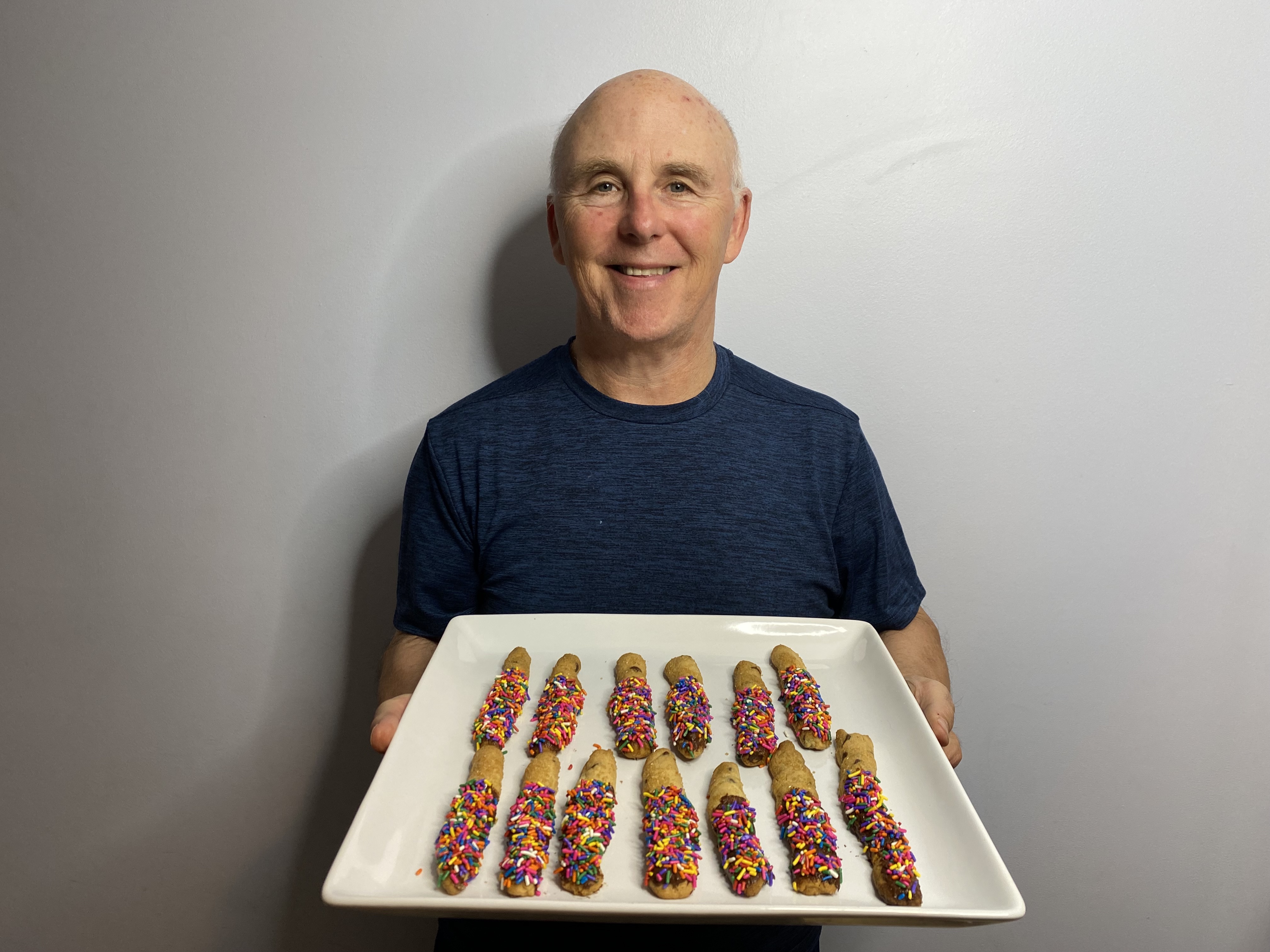 A photo of Chef Rob holding a plate of Sprinkled Cookie Sticks.
