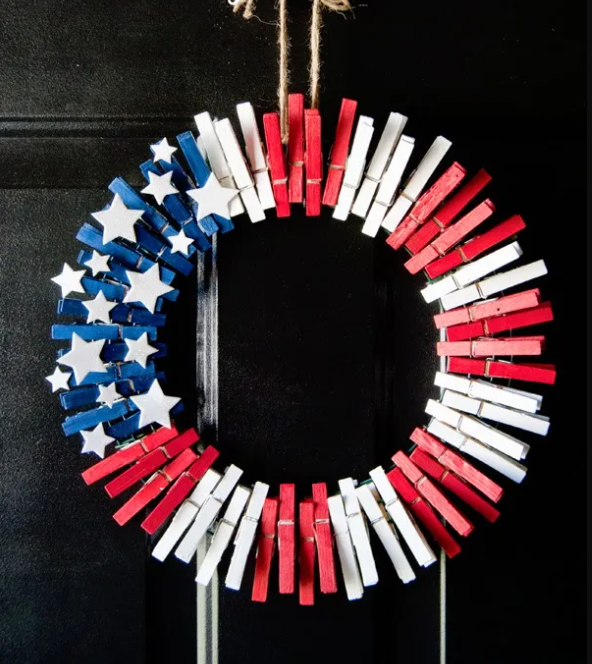 A color photo of a wreath created from clothespins painted red, white and blue.