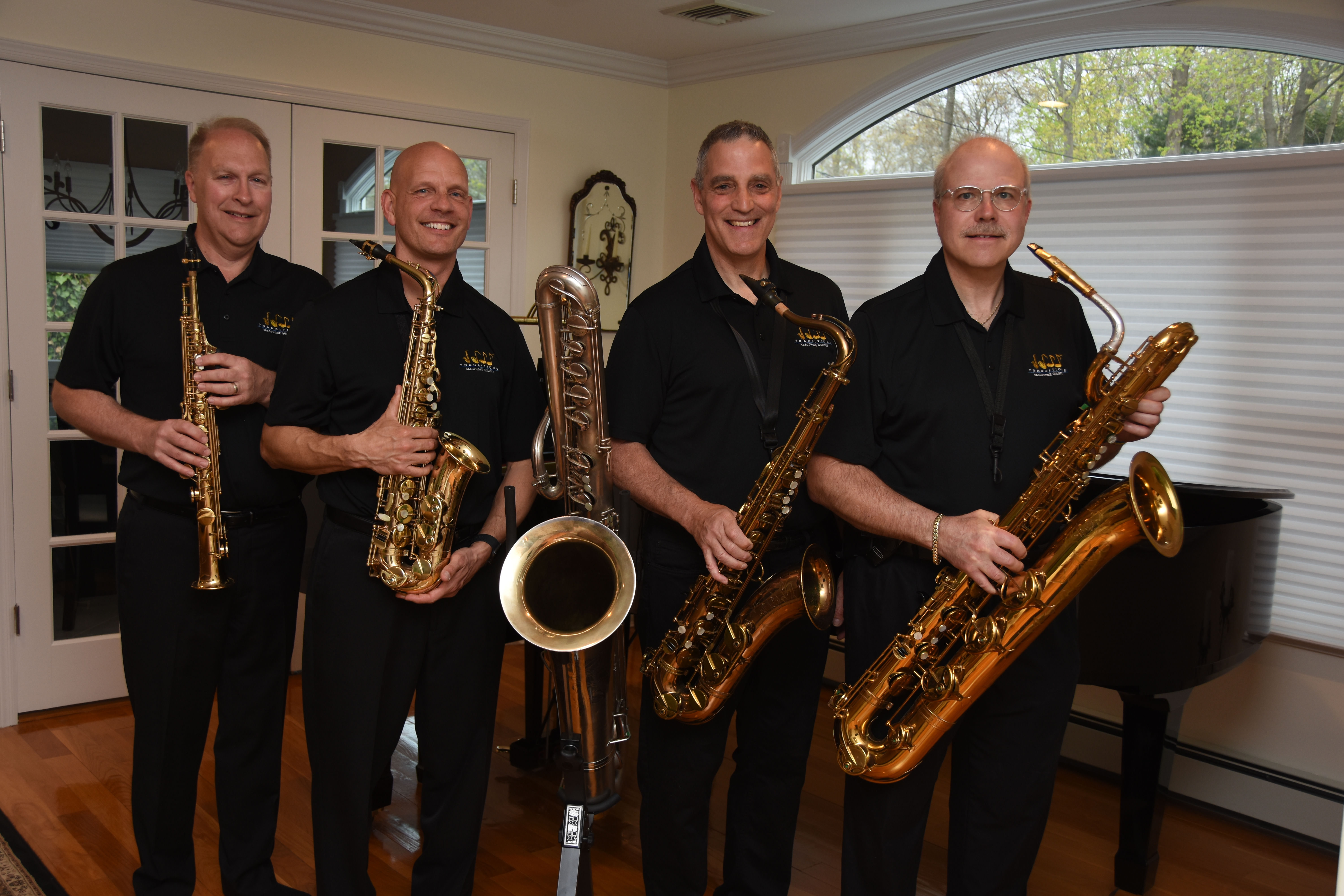Color photo of four members of the Transitions Saxophone Quartet holding their instruments.