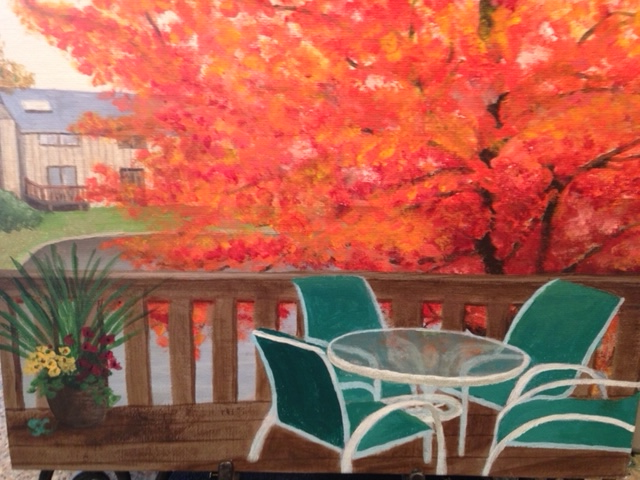 A painting of a tree with colorful red and yellow foliage as seen from an outdoor deck, which features a glass-top table and green chairs.