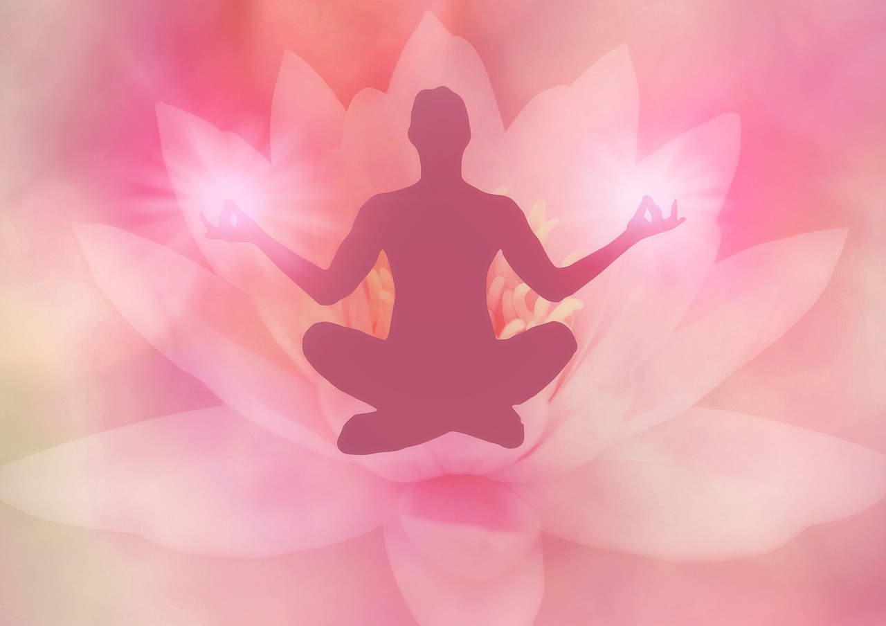 A silhouette of a person sitting cross-legged over a background of a pink lotus flower.