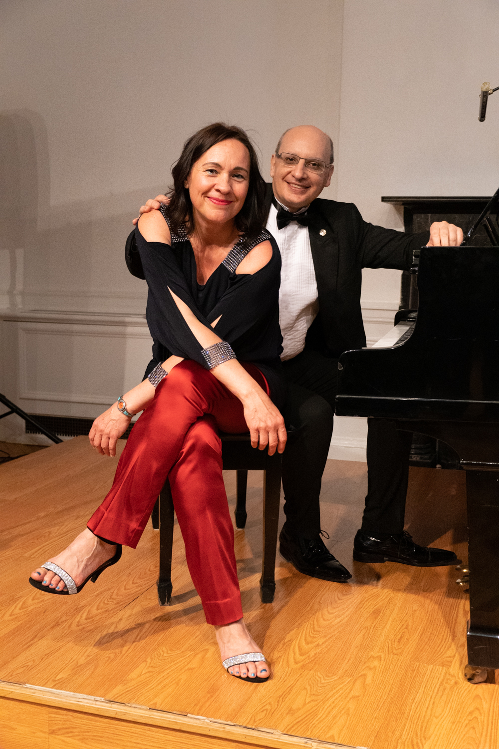 A photo of pianists Evelyn Ulex and Pablo Lavandera posing on a piano bench.