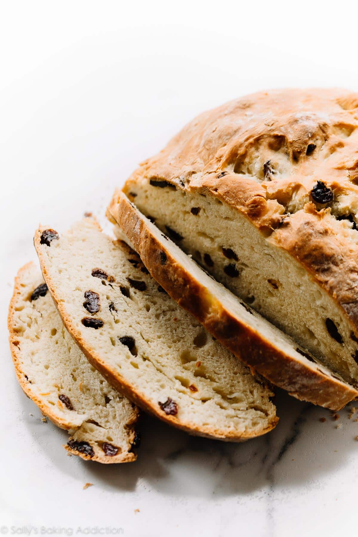 A color photo of a partially sliced loaf of Irish soda bread.