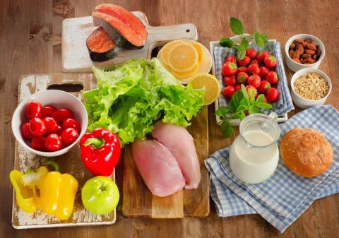 A phot of healthy foods including chicken, peppers, salmon and strawberries.