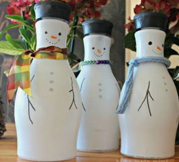 A photo of a trio of snowmen made from upcycled almond milk bottles.