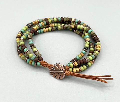 A wrap bracelet made of multi-colored beads on a leather cord.
