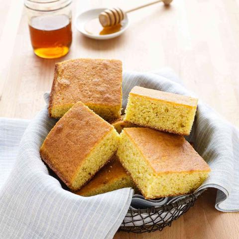A photo of a basket full of cornbread squares.