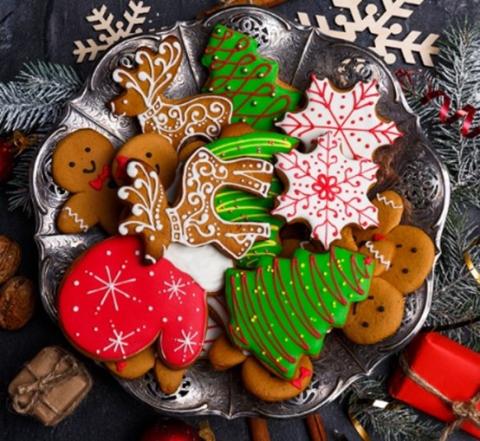 A photo of a plate of holiday cookies decorated with frosting and sprinkles.