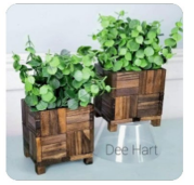 A small plant stand made from Jenga blocks.