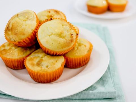 A color photo of a white plate holding six muffins.