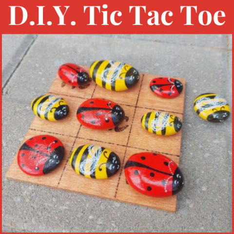 A color photo of a wooden tic tac toe board with insects as game pieces.