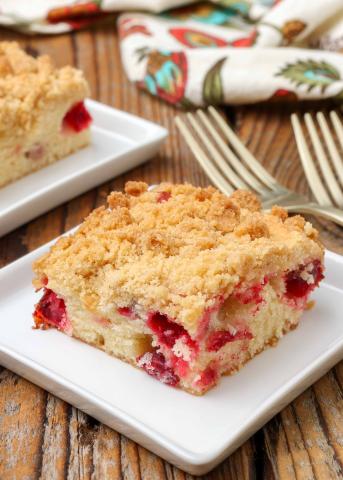 A color photo of a square of cranberry crumb cake.