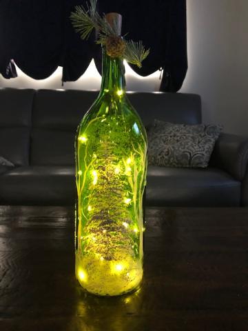 A photo of a painted wine bottle with lights inside.