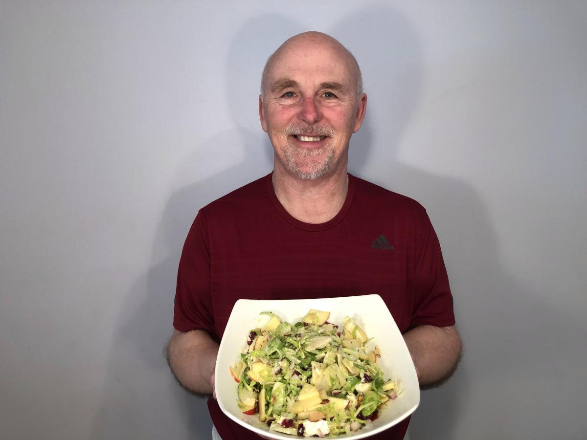 Photo of Chef Rob holding bowl of apple and brussels sprouts salad.
