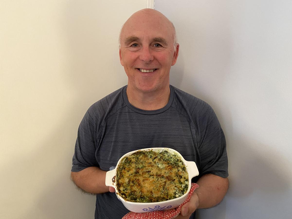 Photo of Chef Rob with a dish of Panko, Parmesan, Spinach & Artichoke Casserole.