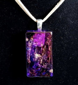 A glass pendant decorated with magenta paint.