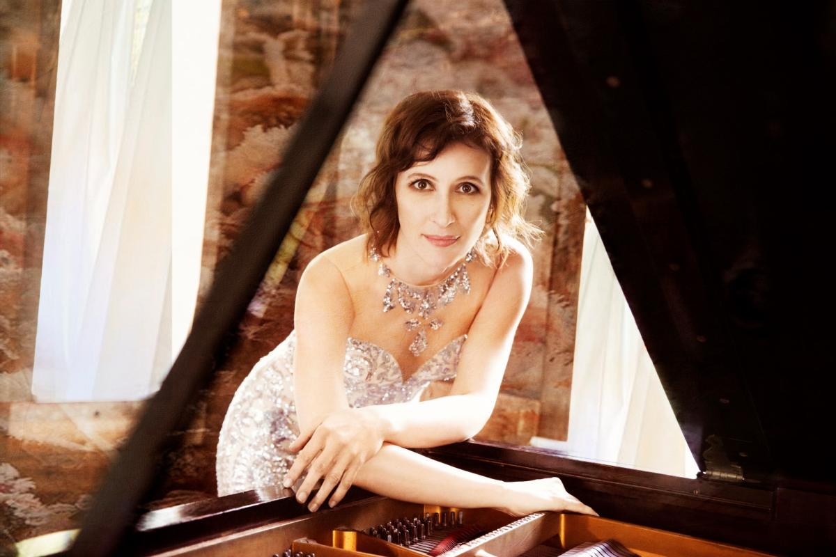 A color photo of pianist Nadeja Vlaeva leaning on an open piano.