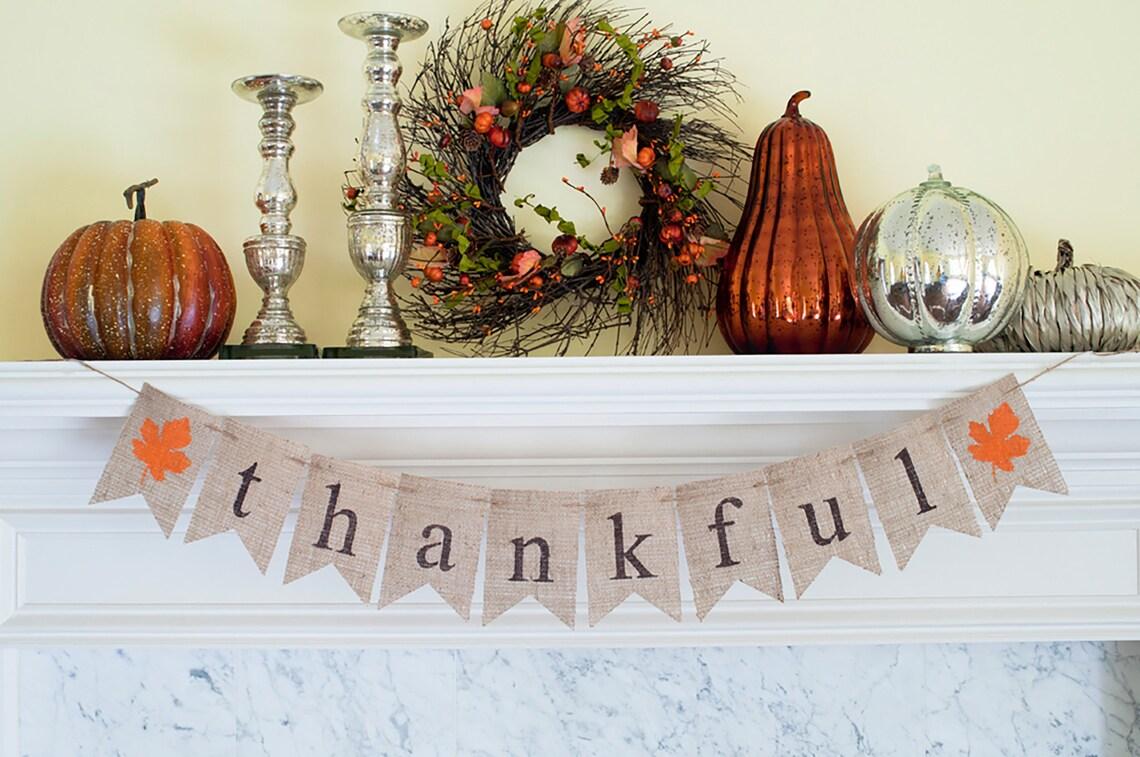 A color photo of the burlap thankful banner hanging from a mantel.