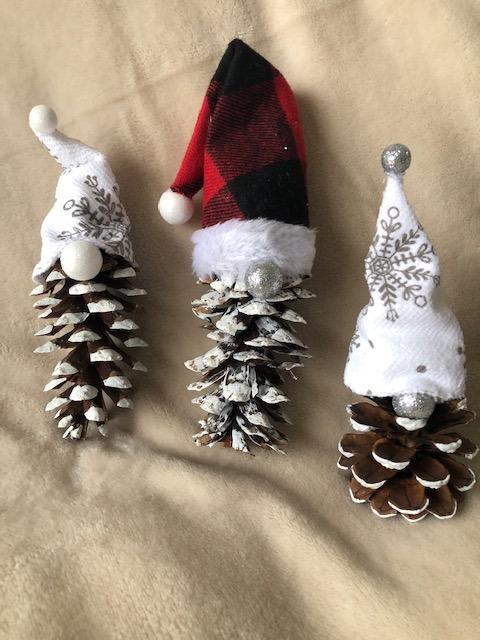 A color photo of three pinecone gnomes.